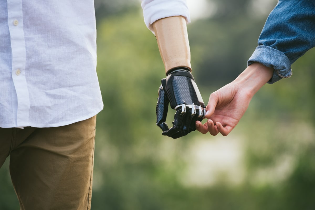 a prosthetic hand and arm holding hands with another person
